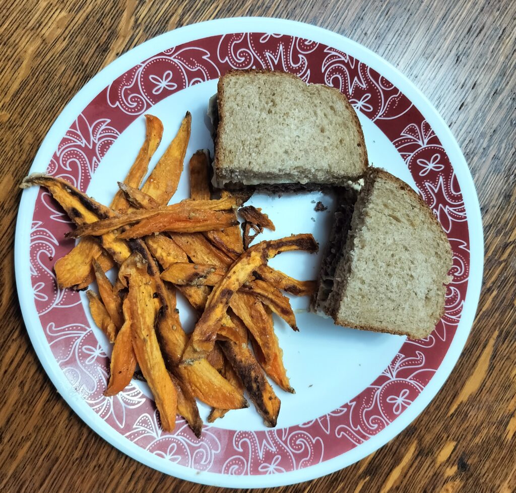 Venison Burger on homemade sandwich bread with sweet potato fries.